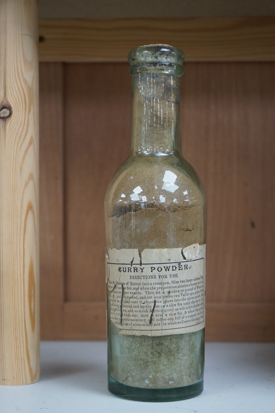 A 19th century sealed bottle of Indian curry powder, with original labels, 28cm high